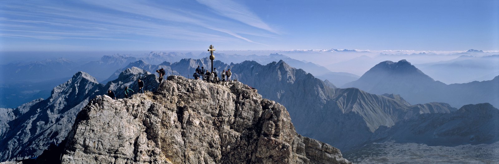 Germany, Bavaria, Zugspitze. Hikers enjoy an inspiring view to the Tirol from the Zugspitze summit in Bavaria, Germany.